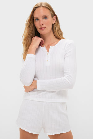 Young woman in a classic White Pointelle Long Sleeve Henley Tee and matching shorts, exuding effortless style. The high-end knit design showcases a fun, sophisticated look.