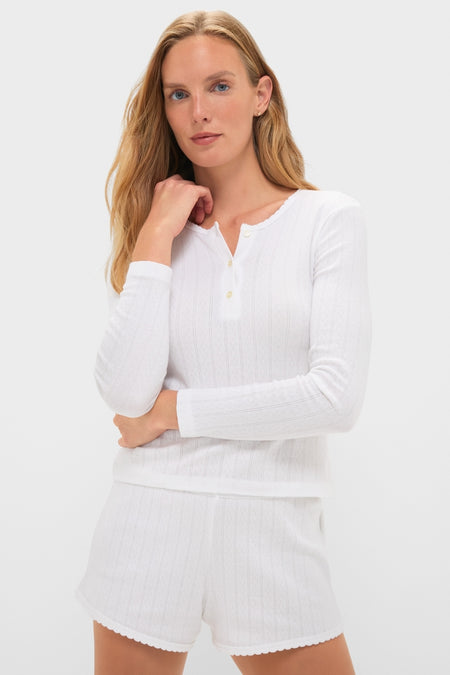 Young woman in a classic White Pointelle Long Sleeve Henley Tee and matching shorts, exuding effortless style. The high-end knit design showcases a fun, sophisticated look.