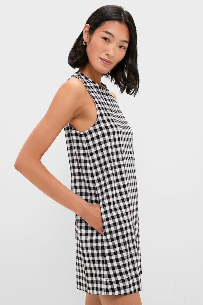 Young woman in profile wearing a classic, high-end Black and White Gingham Mini Dress with side pockets, embodying effortless style and fun, confident fashion.
