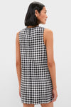 Woman in a classic Black and White Gingham Mini Dress, showcasing an effortless shift silhouette with pockets, perfect for a fun, high-end, and versatile style.