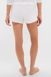 Person in classic, effortless White Pointelle Boxer Shorts with a scalloped hem, embodying a high-end, fun style.