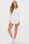 Woman in classic white pointelle boxer shorts and henley top, embodying effortless, high-end loungewear style, perfect for fun, relaxed moments at home.
