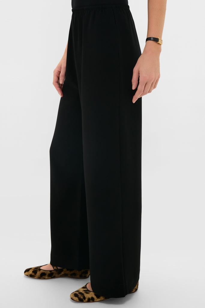Model wearing Black Arielle Pocket Pants, high-waisted, wide-leg, with an elastic waistband and side pockets, styled with leopard-print flats for an effortless, high-end look.