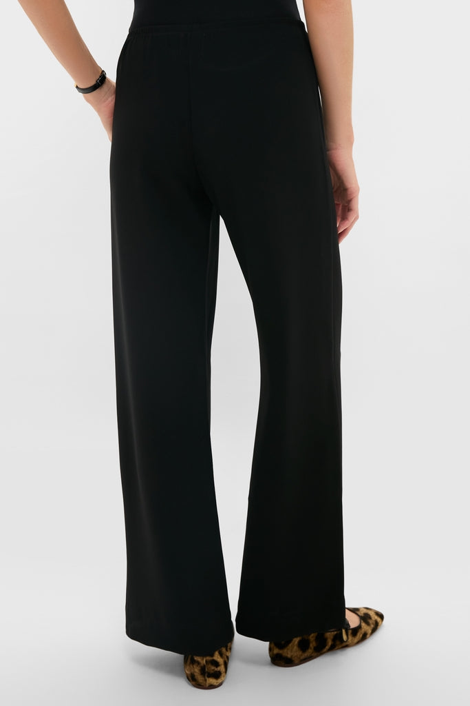 Person wearing Black Arielle Pocket Pants with an elastic waistband and relaxed silhouette, paired with leopard-print flats. Effortlessly classic and high-end style.