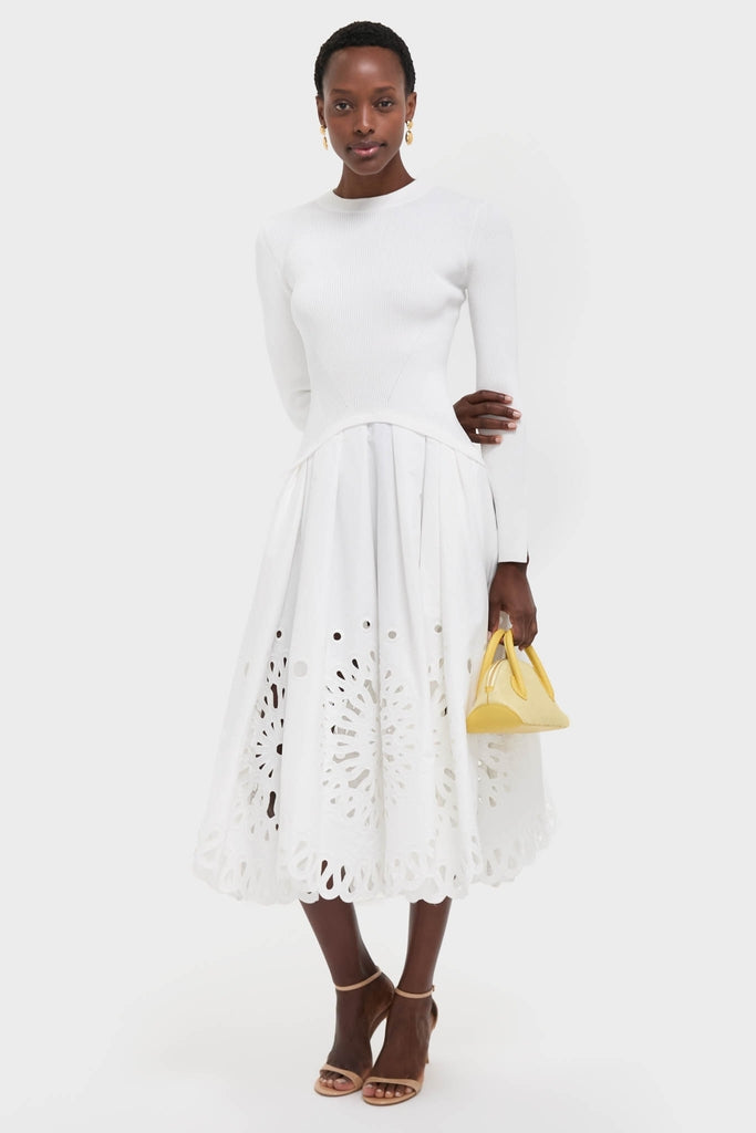 White Daila Midi Dress with ribbed top, eyelet skirt, and scalloped hem exudes classic, effortless elegance. Paired with a yellow handbag for a fun, high-end look.