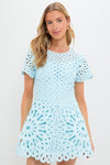 Young woman in a classic, sky-blue Emrys Mini Dress with intricate lace detailing, embodying an effortless, high-end style perfect for both fun casual outings and elegant evenings.