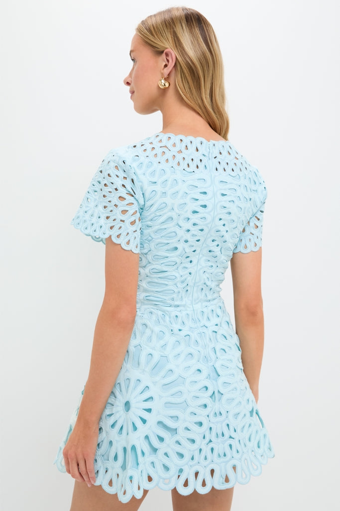 Young woman in a classic, effortless Sky Emrys Mini Dress with intricate lace details, showcasing a high-end, fun style from Tuckernuck.