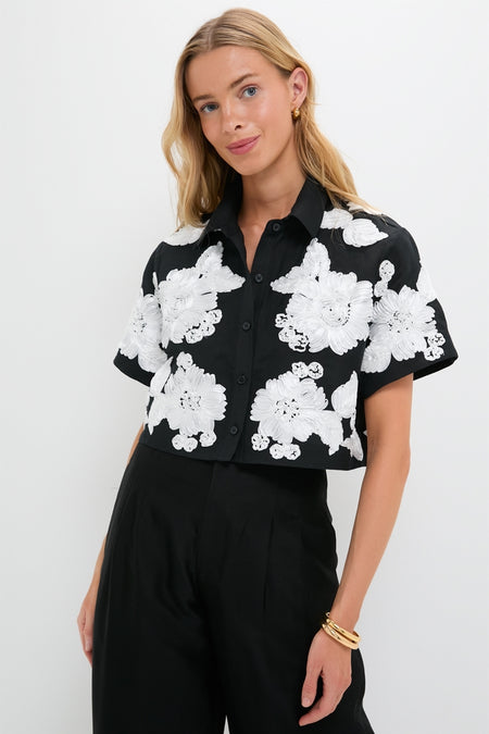 Model wearing Black Multi Callie Camp Shirt with oversized white floral details, paired with high-waisted black trousers. An effortlessly cool, high-end, and classic look.