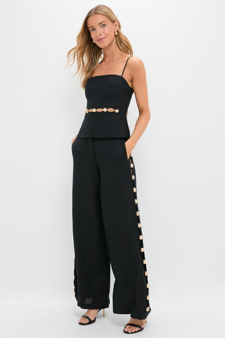 Model in a classic, high-end Black Cayman Wide Leg Pants set with metallic-gold buttons, embodying effortless, fun sophistication in a coordinated, luxury look.