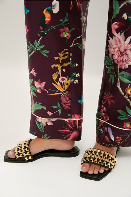 Black Faye Beaded Leather Flat Slides with metallic-gold woven straps, exude a classic, effortless style. Perfect for a fun, high-end tropical look.