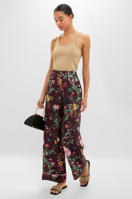 Model wearing Black Faye Beaded Leather Flat Slides, effortlessly styled with a chic, high-end ensemble featuring classic wide-leg botanical trousers and a knit tank.