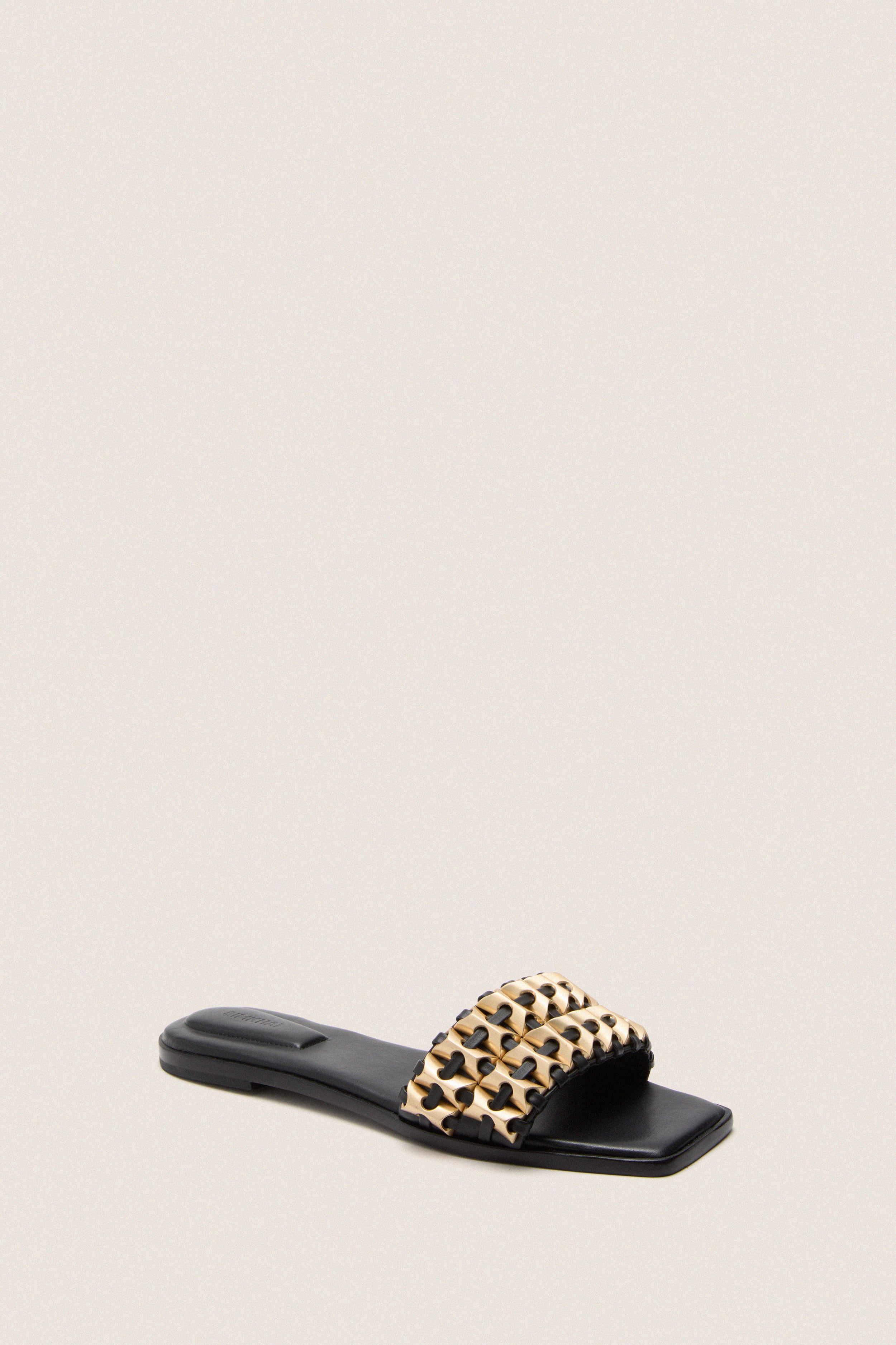 Black Faye Beaded Leather Flat Slides featuring a classic slip-on design with gold-tone woven strap, embodying effortless elegance and high-end style for a fun, versatile look.