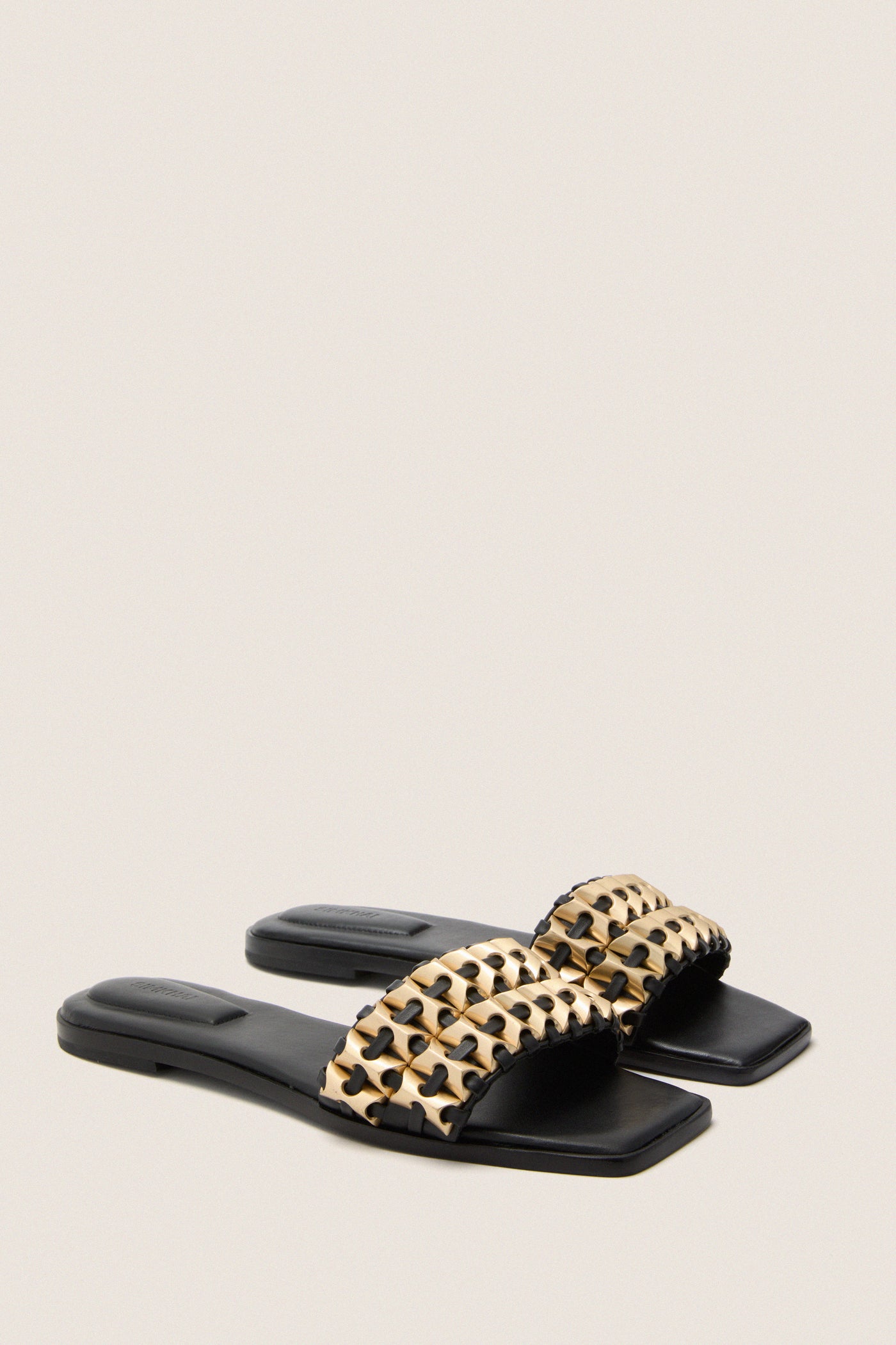 Black Faye Beaded Leather Flat Slides with a classic slip-on design, featuring a woven lattice strap with gold-tone beading. Effortless and high-end, perfect for fun outings.