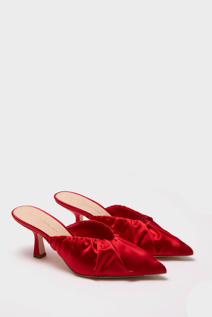 Red Satin Inez Heels: Classic slip-on mules with a glossy red satin finish, featuring a ruched vamp and kitten heel. Effortless elegance for a high-end, fun look.