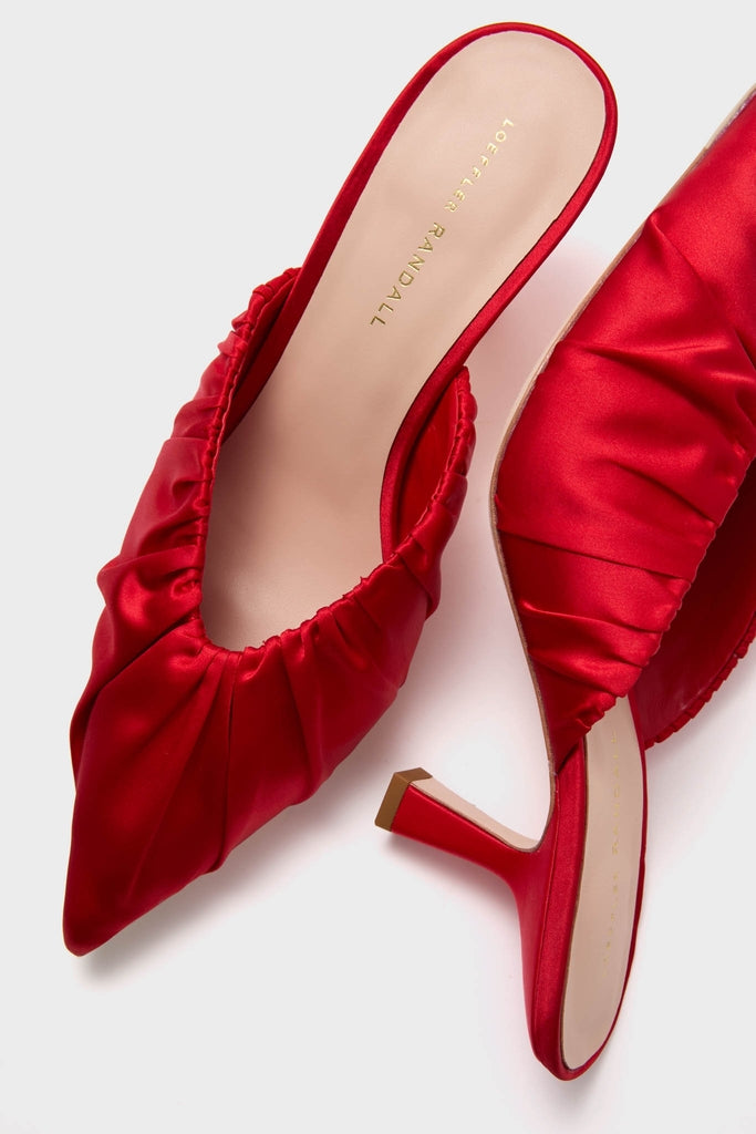 Red Satin Inez Heels: Classic slip-on mules with a pointed toe, gathered upper, and slim mid-height heel, embodying effortless style and high-end fashion.