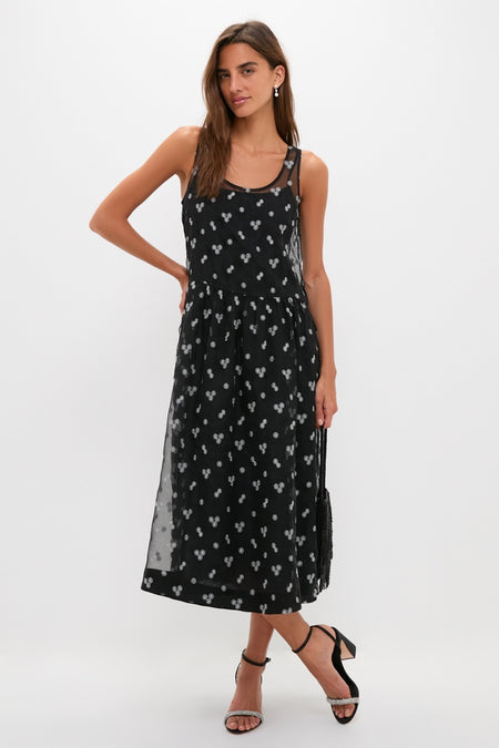 Young woman modeling classic Black Satin with Diamonds Malia Heels, featuring crystal-embellished toe strap and ankle-strap, paired with a chic black dress for an effortless, high-end look.