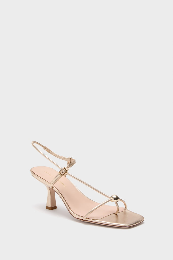 Champagne Metallic Triana Heels: Classic and effortless strappy sandal with a low kitten heel, fun T-strap, and gold ball detail, perfect for high-end occasions.