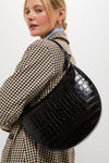 Model showcasing the classic Ebony Croc Embossed Harlow Shoulder Bag, featuring a sleek half-moon shape, gold hardware, and an effortless, high-end style.