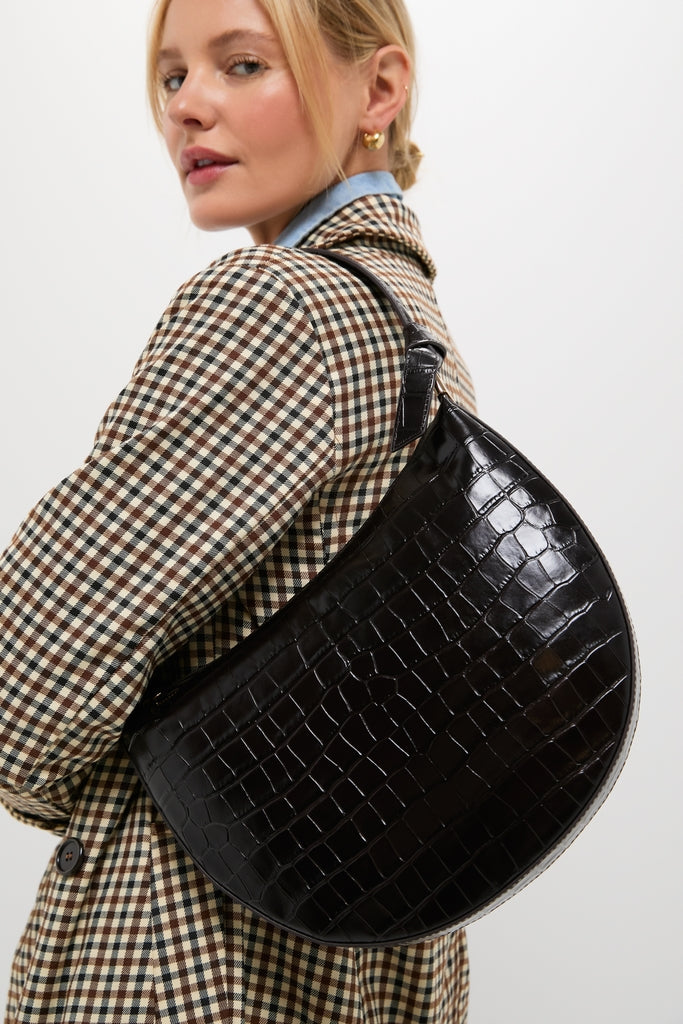 Model showcasing the classic Ebony Croc Embossed Harlow Shoulder Bag, featuring a sleek half-moon shape, gold hardware, and an effortless, high-end style.