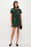 A young woman showcases the classic Green Glimmer Necklace, effortlessly paired with a floral shift dress, embodying a fun and high-end style.