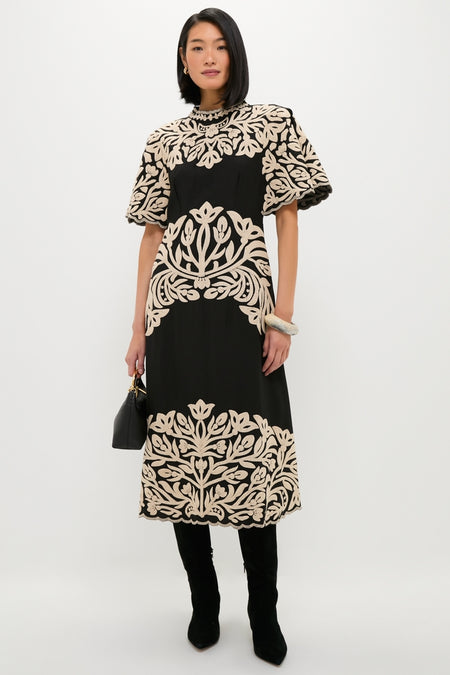 Model wearing an effortlessly classic black dress with bold embroidery, styled with knee-high boots and the Sandy Pearl Rock Medium Bangle, embodies high-end, fun fashion.