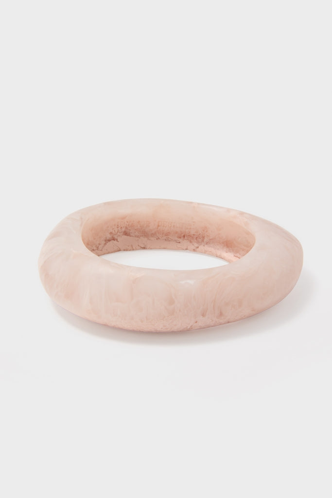 Swirl Rose Rock Small Bangle: A classic, chunky bangle in blush-pink marble. This high-end, effortless piece adds fun sophistication to any look.