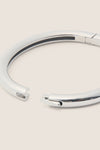 Silver Gia Bangle, a classic and high-end bracelet with a polished finish, featuring a hinge and tab lock, effortlessly blends fun and sophistication for a timeless look.