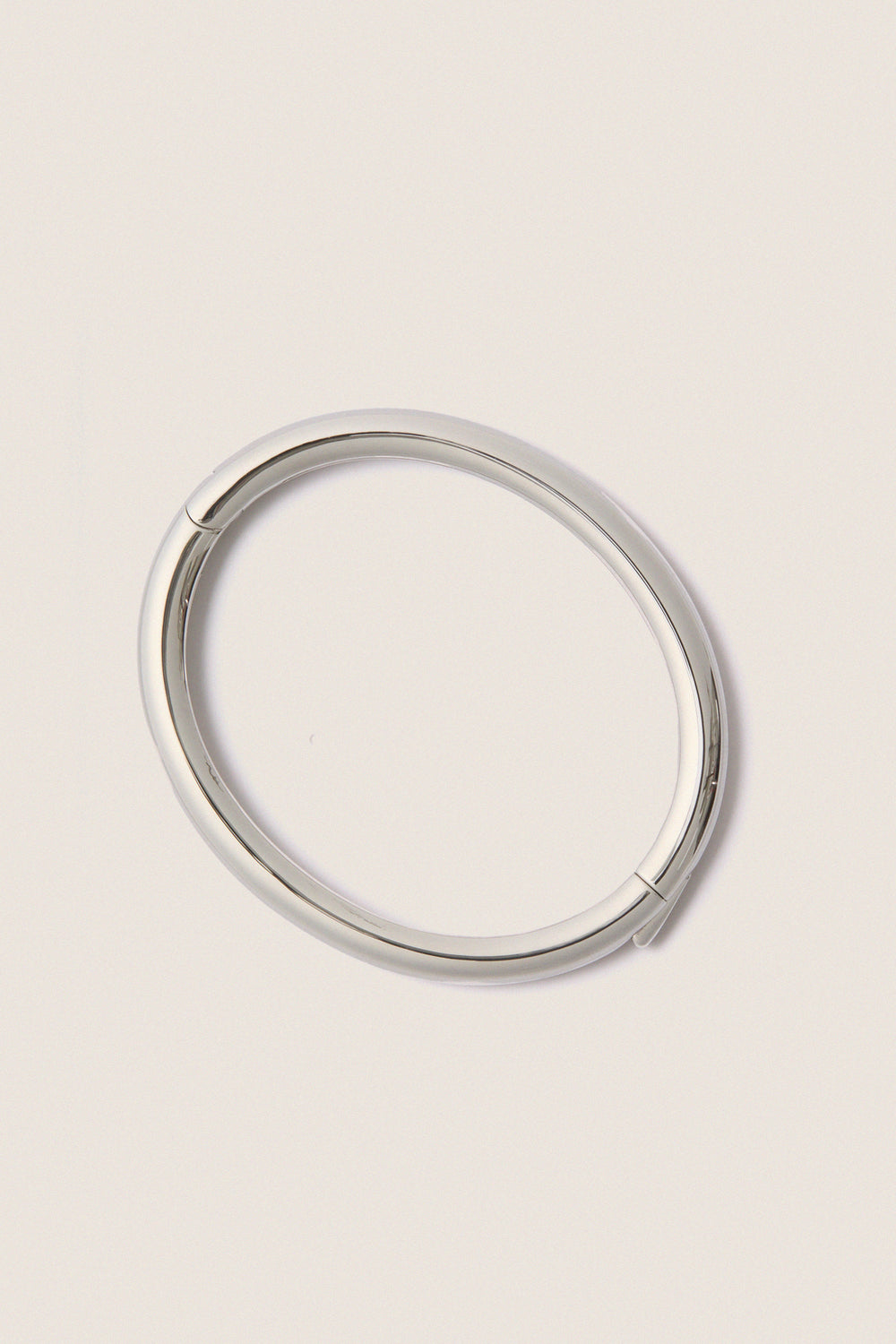 Classic and effortless, the Silver Gia Bangle features a smooth, polished surface with a hinge push closure, embodying a fun, high-end style ideal for any occasion.