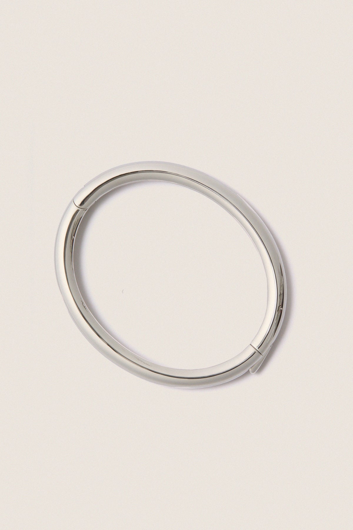 Classic and effortless, the Silver Gia Bangle features a smooth, polished surface with a hinge push closure, embodying a fun, high-end style ideal for any occasion.