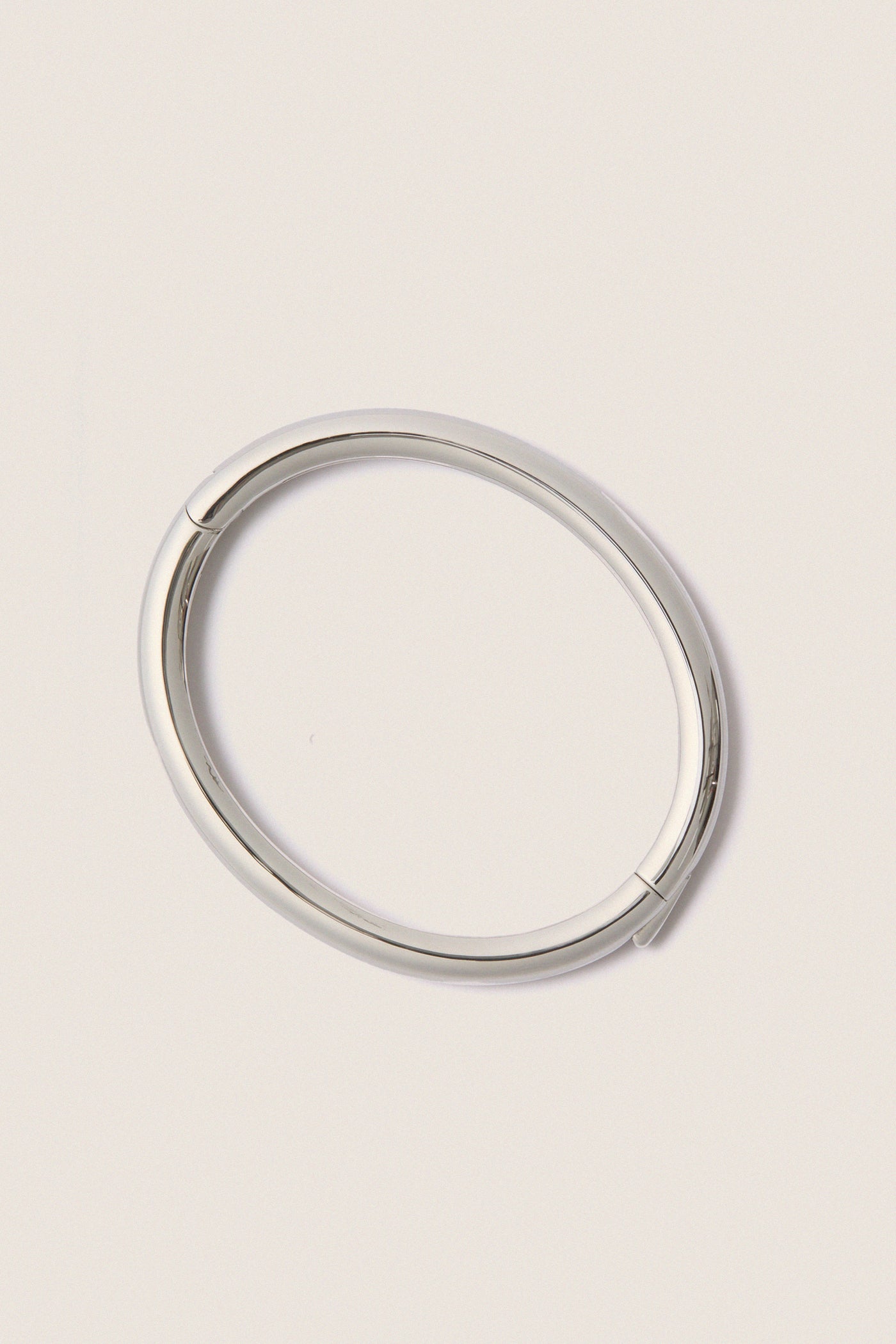 Classic and effortless, the Silver Gia Bangle features a smooth, polished surface with a hinge push closure, embodying a fun, high-end style ideal for any occasion.