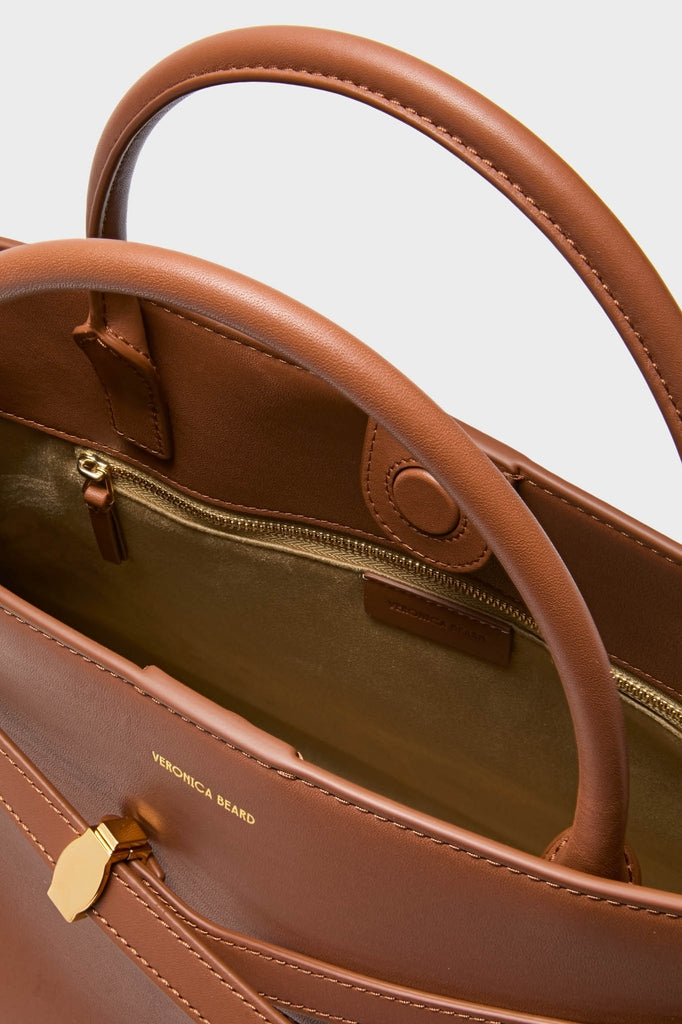 Hazelwood Large Veronica Beard Dash Bag in cognac leather, featuring classic top handles, effortless magnetic closure, fun removable strap, and high-end interior gold-tone zip pocket.