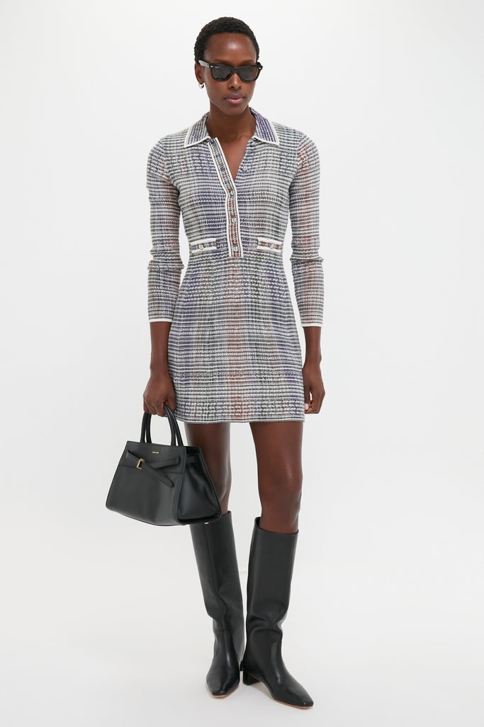 Model in multicolored knit dress, classic black leather knee-high boots, and sunglasses, carrying an effortless, high-end Black Veronica Beard Dash Bag with a structured handle.