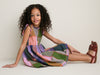 Young girl wears the classic Plaid Madras Alyssa Dress, featuring playful patchwork, ruffle details, and silver buttons, paired with effortless brown sandals and a simple necklace.