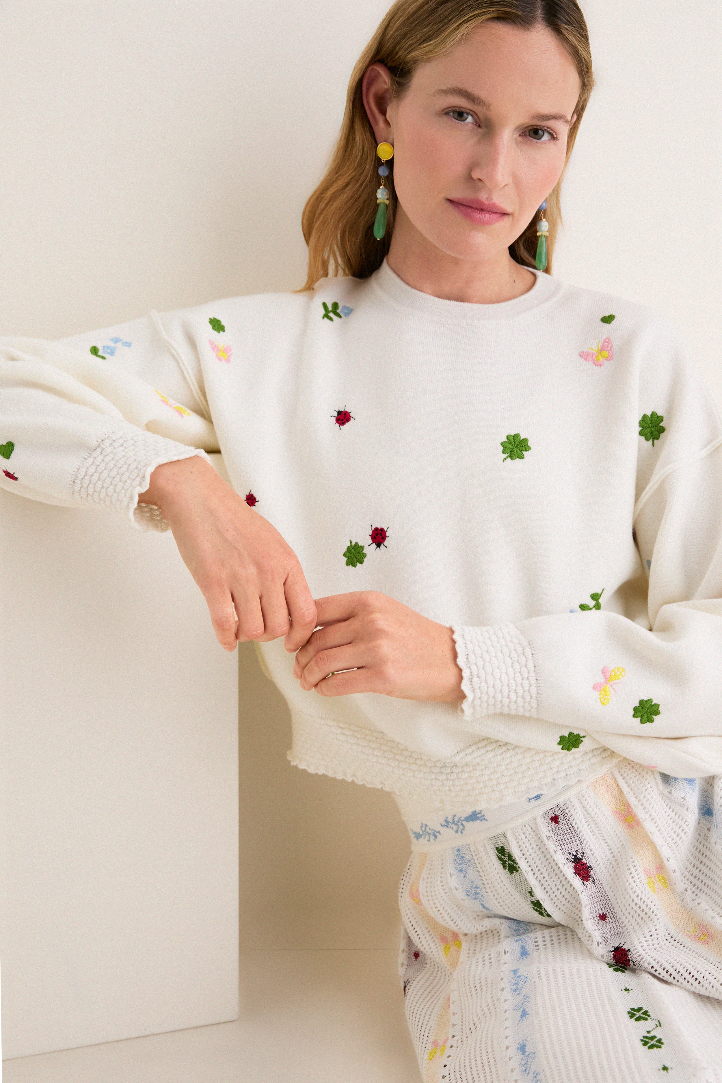 Model wearing the classic Milk Multi Dump Sweater with whimsical embroidery, showcasing an effortless, high-end look. The soft knit top exudes fun, spring vibes.
