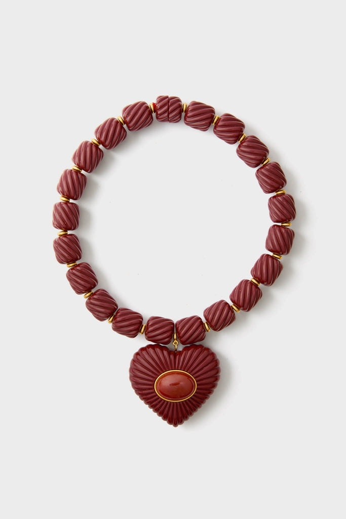 Burgundy Lira Necklace: A classic, high-end chunky necklace with deep red square beads and a heart-shaped pendant, offering an effortless, fun elegance.