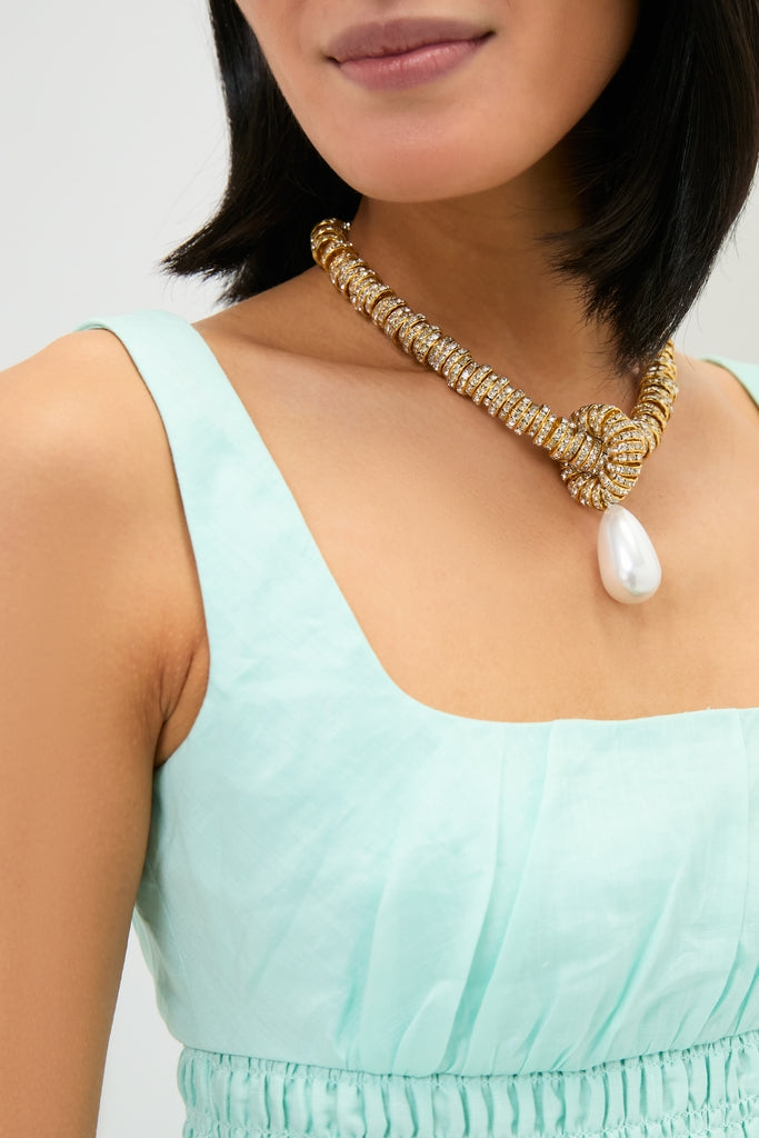 Woman wearing the Gold Pearl Drop Necklace, featuring a bold, gold rope design with diamond accents and a classic, teardrop-shaped pearl, exuding an effortless high-end elegance.