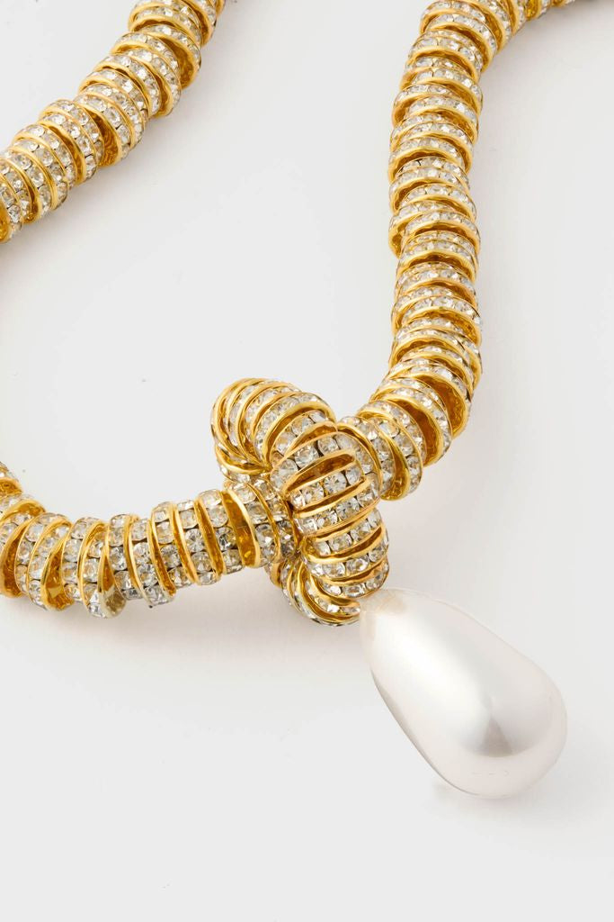 Gold Pearl Drop Necklace: A classic, high-end piece featuring gold-tone metal rings with crystal stones, knotted with a teardrop pearl pendant for an effortless, fun look.