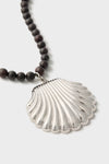 Silver Holbox Necklace: A classic, high-end design featuring dark beads and an oversized shell-shaped pendant, effortlessly elevating any look with fun sophistication.