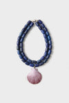 Navy and Lilac Luma Necklace: A classic double-strand design of chunky blue beads with a pinkish-purple scallop shell pendant, offering an effortless and high-end look.