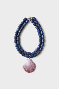 Navy and Lilac Luma Necklace: A classic double-strand design of chunky blue beads with a pinkish-purple scallop shell pendant, offering an effortless and high-end look.