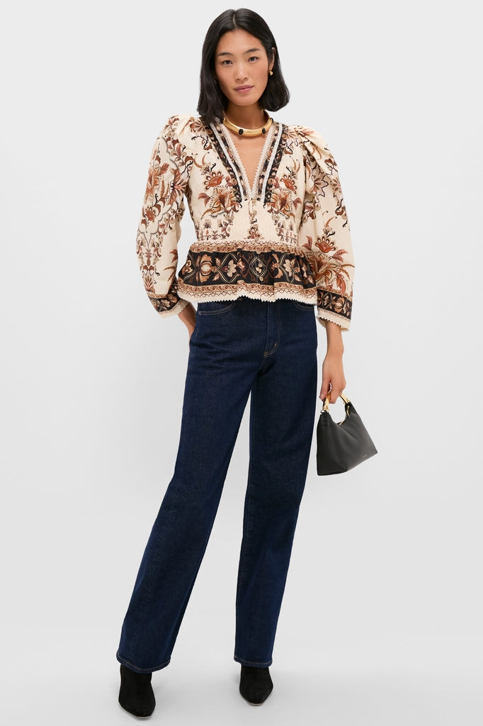 Person wearing a classic, effortless ensemble with a Gold Celeste Necklace, showcasing fun elegance. Styled with high-end dark jeans, boots, and a chic handbag.