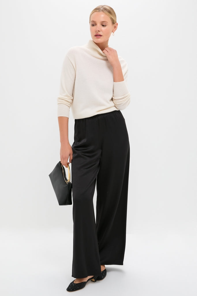 Model wearing classic Gold Mini Pave Puffy Heart Earrings, crystal-encrusted, with a sleek handbag and stylish outfit, embodying effortless, high-end fashion.