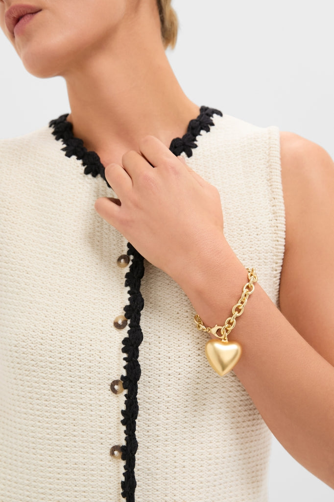 Close-up of a classic, high-end Gold Puffy Heart Bracelet with a polished heart charm, worn on the wrist, adding effortless fun to any outfit.