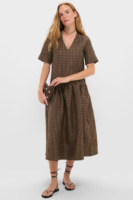 Model in a gingham dress showcases the Gold and Black Spark Necklace, with its classic pavé sphere, adding an effortless, high-end touch.