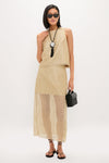 Model showcases an effortless, classic look with the Black Nautilus Necklace, pairing it with a structured black woven bag and strappy sandals for a high-end, fun style.