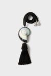 Black Nautilus Necklace: A classic, high-end accessory featuring a twisted black rope with silver-tone caps, iridescent spiral shell pendant, and an effortless black tassel, perfect for fun occasions.
