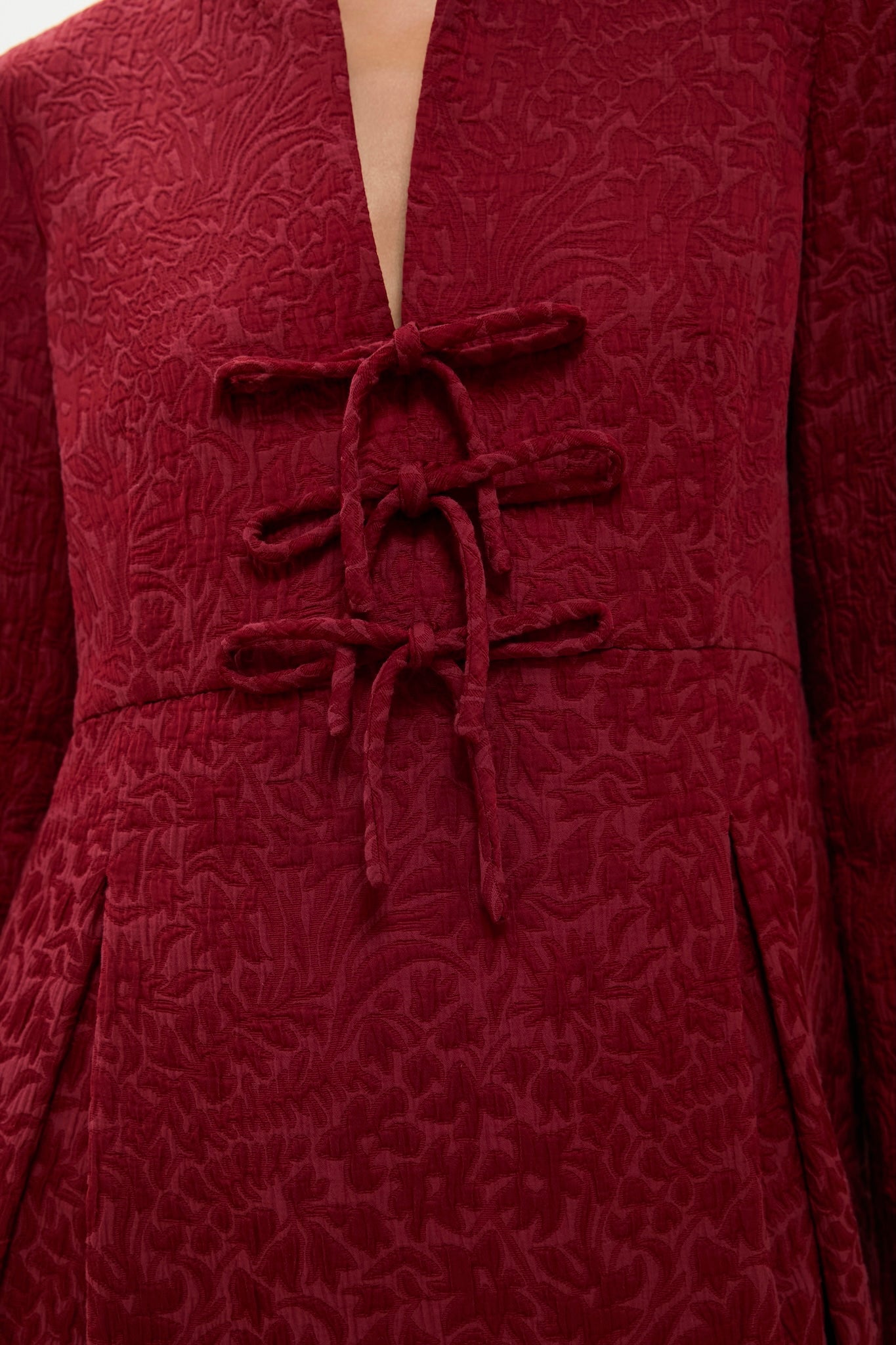 Classic Cranberry Jacquard Blair Bow Dress with elegant frog closures and raised floral pattern, featuring an effortless V-neck and sophisticated A-line silhouette for a high-end look.