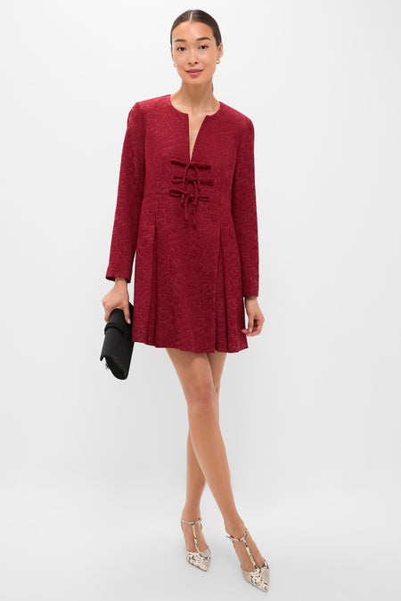 Model in Cranberry Jacquard Blair Bow Dress, featuring classic bow details and an effortless A-line silhouette, styled with fun T-strap heels and a high-end black clutch.