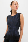 Woman wearing the classic Navy and Black Lace Margy Top, featuring an effortless peplum design with fun lace details, exuding a high-end, versatile style.