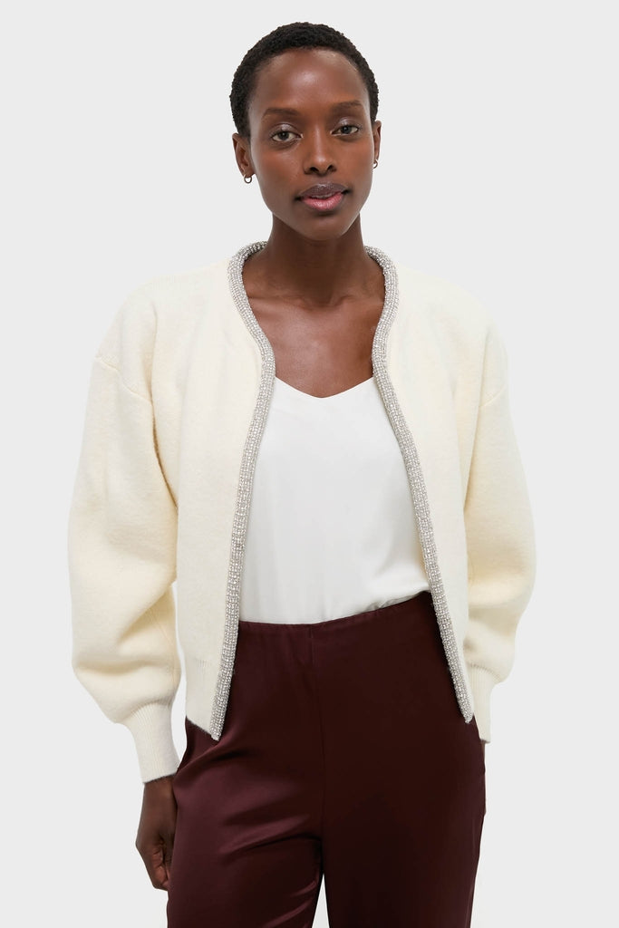 Ivory Sequin Trim Naomi Cardigan on a woman, paired with a white V-neck top and burgundy trousers, showcasing a classic, effortless, and high-end style.